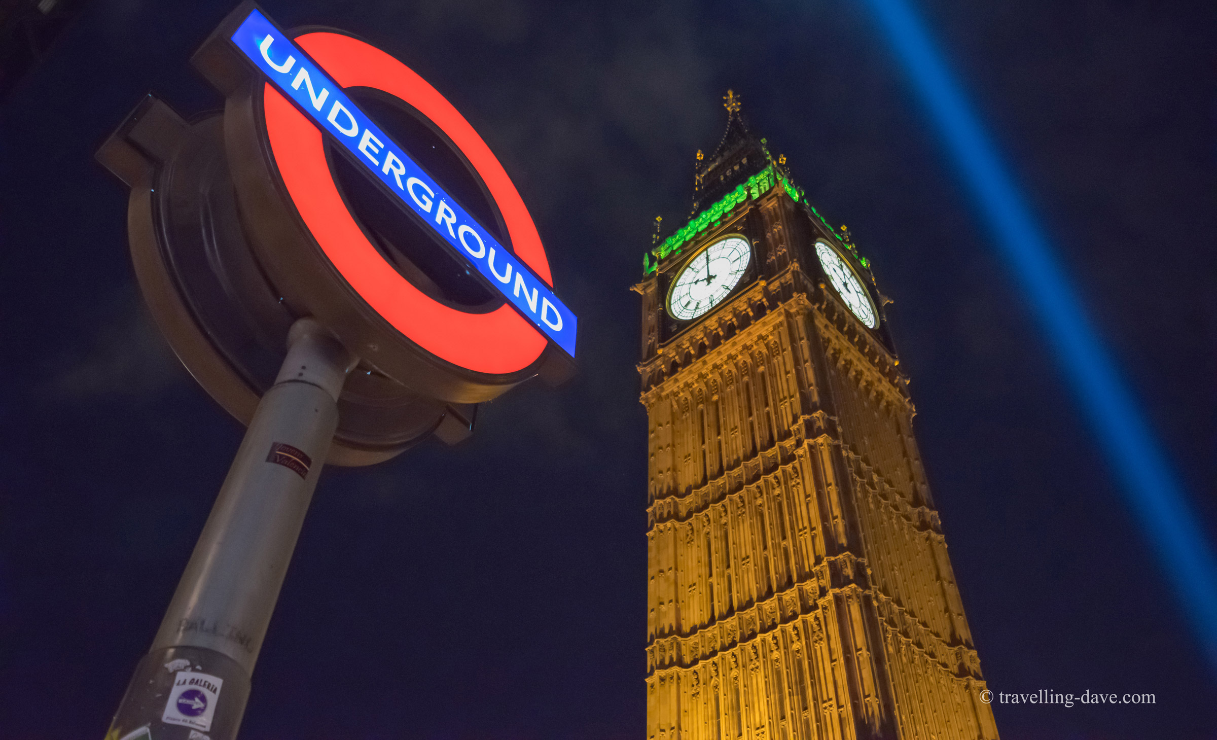 Tube sign and Elizabeth Tower at night.